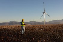 Engineer using mobile phone at wind farm — Stock Photo