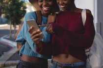 Twins siblings taking selfie with mobile phone in city street — Stock Photo