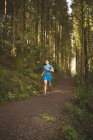 Giovane uomo che corre nella foresta — Foto stock