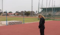 Giovane atleta donna in piedi sulla pista da corsa — Foto stock