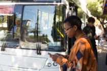 Женщина разговаривает по мобильному телефону на автобусной остановке — стоковое фото