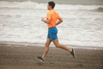 Jovem correndo na praia — Fotografia de Stock