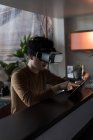Человек в наушниках виртуальной реальности с помощью цифрового планшета дома — стоковое фото