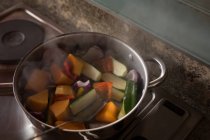Primer plano de las verduras cocinadas en una sartén en casa - foto de stock
