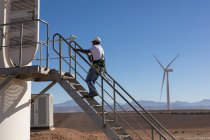 Ingenieur klettert die Treppe einer Windkraftanlage in einem Windpark hinauf — Stockfoto