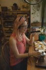 Junge Frau beim Frühstück im Café mit dem Handy — Stockfoto