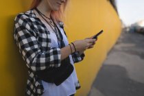 Junge Frau benutzt Handy auf Gehweg — Stockfoto