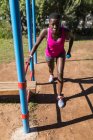 Atleta donna determinata con manubri che si esercitano vicino alle sbarre — Foto stock