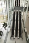 Vista de ángulo alto de los empresarios en la escalera mecánica en la oficina - foto de stock