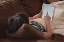 Ragazza che utilizza tablet digitale in soggiorno a casa — Foto stock