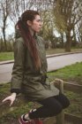 Nachdenkliche Frau entspannt sich auf Holzzaun — Stockfoto