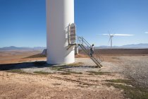 Ingegnere che scende le scale di un mulino a vento in un parco eolico — Foto stock