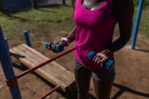 Partie médiane de l'athlète féminine faisant de l'exercice avec haltères — Photo de stock