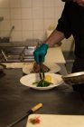 Chef di sesso maschile che serve cibo in un piatto del ristorante — Foto stock
