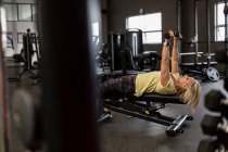 Femme handicapée faisant de l'exercice sur machine dans la salle de gym — Photo de stock