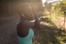 Atleta feminina determinada ouvindo música durante o treino matinal — Fotografia de Stock