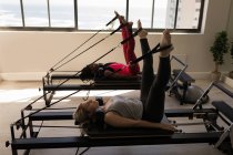 Zwei Frauen trainieren im Fitnessstudio auf einem Stretchgerät — Stockfoto