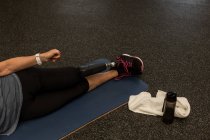 Mulher com deficiência realizando exercício de alongamento no ginásio — Fotografia de Stock
