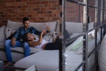 Couple using mobile phone in living room at home — Stock Photo