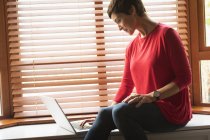 Primo piano della donna che utilizza il computer portatile in soggiorno a casa — Foto stock