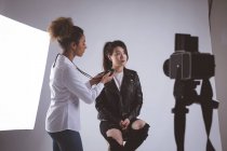 Photographe femelle enregistrant une interview à l'aide d'un enregistreur vocal dans un studio photo — Photo de stock
