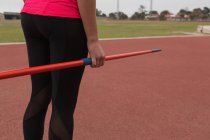 Mid section of female athlete practicing javelin throw — Stock Photo