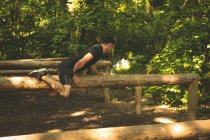 Entrenamiento de hombre en forma en el sendero de fitness en el campamento de entrenamiento - foto de stock