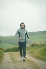 Fit man jogging through landscape — Stock Photo