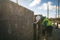 Концентрированный инженер, осматривающий стену на строительной площадке — стоковое фото