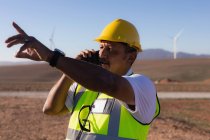 Інженер розмовляє на мобільному телефоні на вітроелектростанції — стокове фото