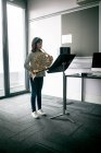 Adorable schoolgirl playing french horn in music school — Stock Photo