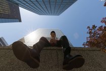 Visão de baixo ângulo do homem usando o telefone celular na cidade — Fotografia de Stock