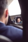 Rear view of businessman driving a car — Stock Photo