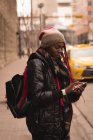 Молодая женщина с мобильного телефона на городской улице — стоковое фото