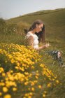 Beautiful woman sitting in a meadow — Stock Photo
