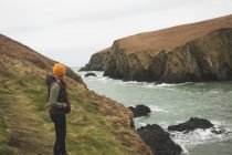 Вид сбоку на женщину-туристку, стоящую у берега — стоковое фото