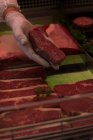 Metzger entfernt Fleisch aus Auslage in Metzgerei — Stockfoto