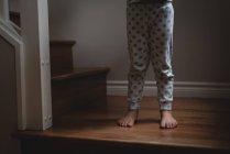 Seção inferior da menina de pé nas escadas em casa — Fotografia de Stock
