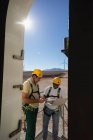 Инженеры, стоящие у входа ветряной мельницы на ветряной электростанции — стоковое фото
