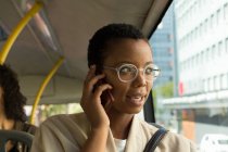 Женщина разговаривает по мобильному телефону во время поездки в автобусе — стоковое фото