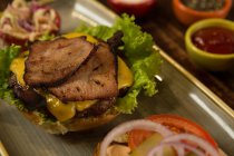 Primer plano de la hamburguesa de carne servida en bandeja - foto de stock