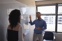 Dirigenti aziendali che discutono sulla lavagna bianca in ufficio — Foto stock