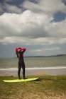 Surfista con tabla de surf preparándose para surfear en un día soleado - foto de stock