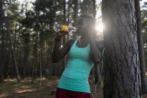 Жінка атлет питної води в лісі — стокове фото