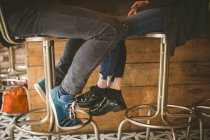 Primo piano di gambe di coppia seduto al bancone del bar — Foto stock