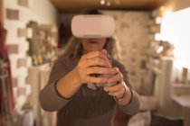 Женщина-гончар, использующая гарнитуру виртуальной реальности дома — стоковое фото