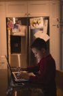 Вид сбоку на мальчика, использующего ноутбук дома — стоковое фото