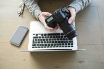 Overhead view of man using digital camera at home — Stock Photo