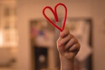 Close-up of girl holding heart shape decoration at home — Stock Photo
