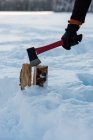 Tronco de madera macho de corte manual con hacha en nieve . - foto de stock